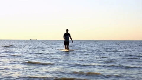 Silhouette of man walking on the beach during sunset over sea. Guy on active Stock Footage 134846582