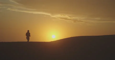 Silhouette of a man walking over desert ... | Stock Video | Pond5