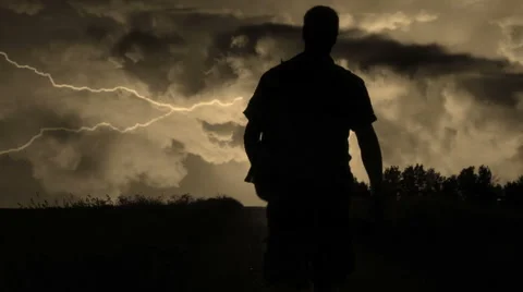 Silhouette of a man walking into the storm Stock Footage 61031544
