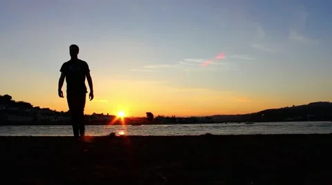 Silhouette of man walking, sun setting Stock Footage 48750292