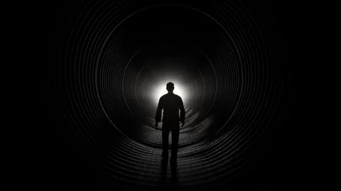 Silhouette of Man Walking Towards Light in Dark Tunnel Stock Footage 315920611