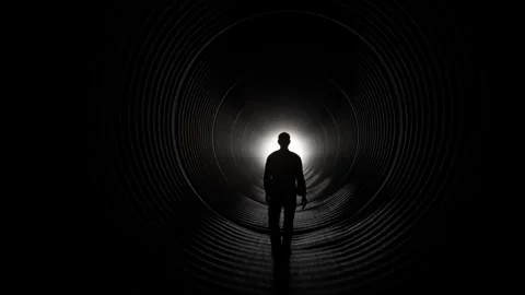 Silhouette of Man Walking Towards Light in Dark Tunnel Stock Footage 315920637