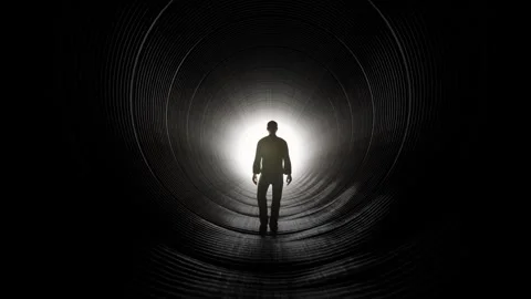 Silhouette of Man Walking Towards Light in Dark Tunnel Stock Footage 315920756