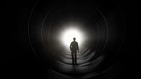 Silhouette of Man Walking Towards Light in Dark Tunnel Stock Footage 315920776