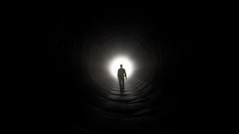 Silhouette of Man Walking Towards Light in Dark Tunnel Stock Footage 315920827