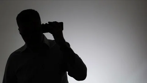 Silhouette of a man on a white background, which listens to an audio message in Stock Footage 105412458