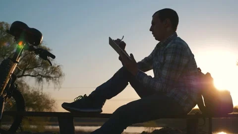 Silhouette of a man working on a digital tablet remotely while traveling. A Stock-Footage 132207850