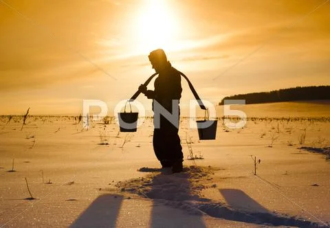 Silhouette Of Mari Man Carrying Buckets On Traditional Yoke In Snowy Field