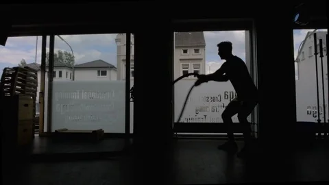 Silhouette of men with rope in functional training fitness gym in a crossfit Stock Footage 113701661