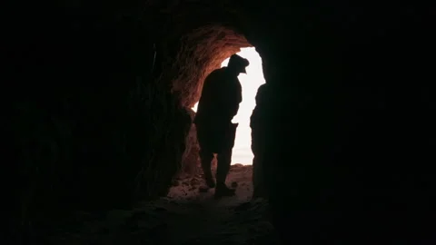 Silhouette of a miner exploring a dark cave with a headlamp Video stock 343318926