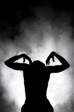 Silhouette modern ballet dancer posing on dark background with smoke Stock Photos