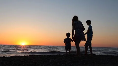 Silhouette of mom and son at Sunset Beach sea ocean Stock Footage