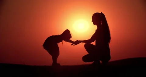 Silhouette of mother and little daughter having fun playing at sunset, slow Stock Footage
