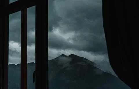 The silhouette of a mountain in the clouds. View from the window Stock Photos