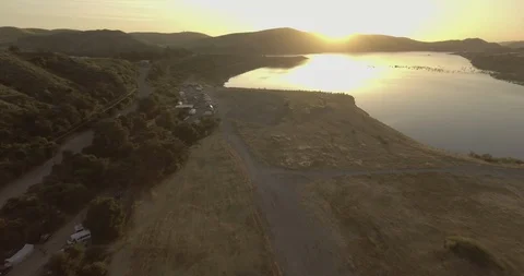 Silhouette mountains and sun reflection on lake at sunset Stock Footage 104820219