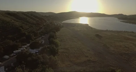 Silhouette mountains and sun reflection on lake at sunset Stock Footage 104823223