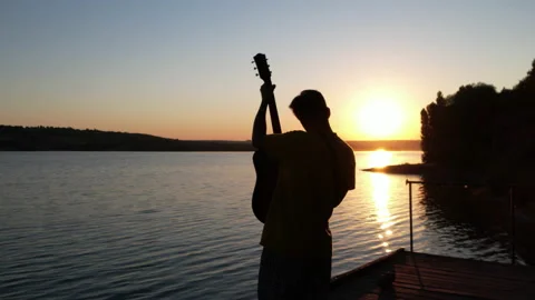 Silhouette of musician playing on the beach. Guitar performance Stock Footage