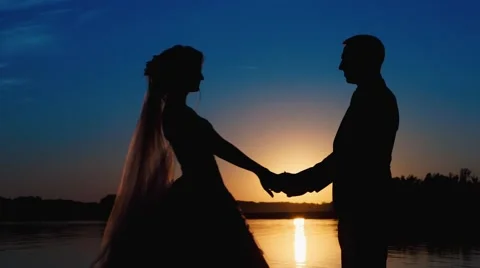 Silhouette newlyweds at sunset Stockbeeldmateriaal 56497826