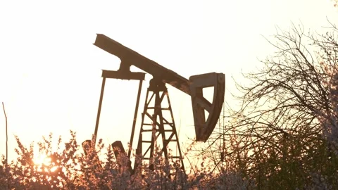 Silhouette of an Oil Pump Jack at Spring Golden Sunset Stock Footage 332979115