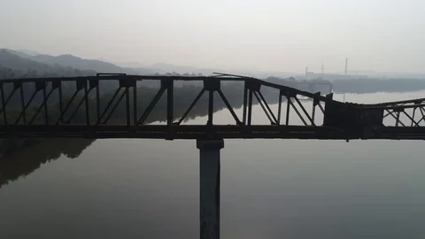 Silhouette of old, long, rusty truss-type aqueduct over the river. Aerial view. Stock Footage 85453019