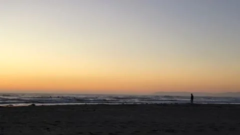 Silhouette of an old man in a cowboy hat is on the ocean beach at sunset Stock Footage 201894530