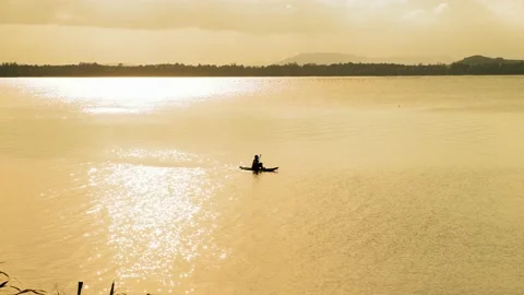 Silhouette of old man floating in a small boat. Stock Footage 154521031