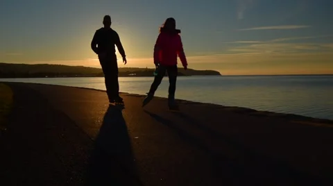 Silhouette pair of roller skates, sunset on the sea coast Video stock 60232576