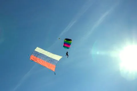Silhouette of a parachutist flying in the sky to the sun Stock Photos