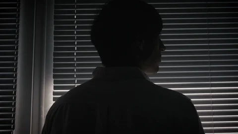 Silhouette of paranoid man looking through blinds Stock-Footage 88972736