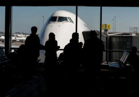 Silhouette of Passengers Waiting for Their Flight Stock Photos