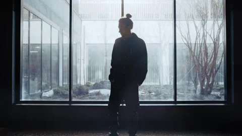 Silhouette of a pensive man waiting by the window 스톡 동영상 335474293