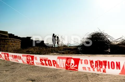 Silhouette of people beyond a danger, stop do not cross line at indian temple Stock Photos