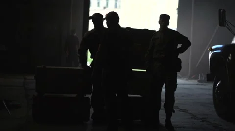 Silhouette of people in the hangar on the background of the boxes Stock Footage 61802940