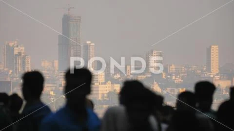 Silhouette of people in Mumbai on the background of the city skyscrapers. Stock Photos