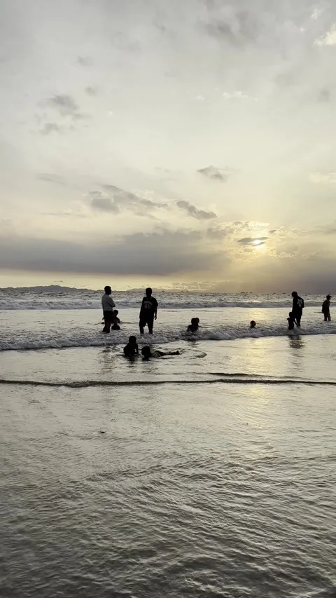 Silhouette of People Playing on Beach at Sunset with Reflection Stock Footage 332456193
