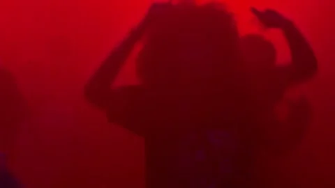 Silhouette of person enjoying the dancing at a concert in nightclub Stock Footage