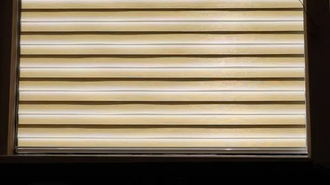 Silhouette of persons walking behind window blinds 스톡 동영상 327971928