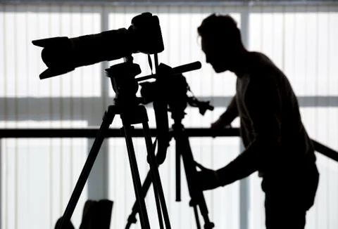 Silhouette of photographer and cameraman shot the video on a tripod at the wo Stock Photos