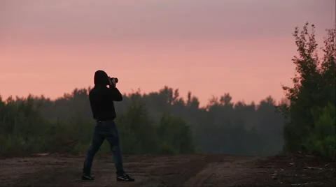 Silhouette of photographer taking photos Stock Footage
