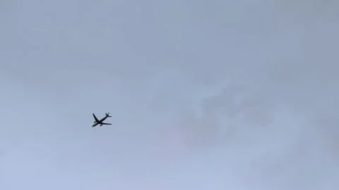 Silhouette of a plane flying before landing on the background of evening sky. 動画素材 280754710