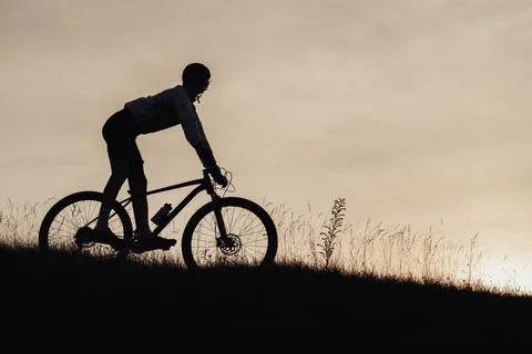 Silhouette of Professional Cyclist Descend from a Hill on a Bicycle, Sportsman Stock Photos