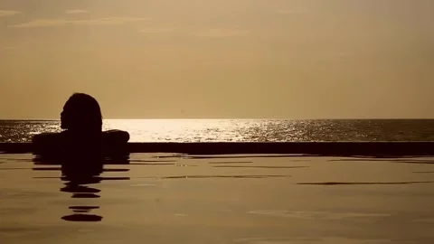 Silhouette Relaxing in Pool at Sunset Stock Footage 288706205