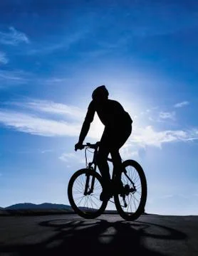 Silhouette of riding cyclist Stock Photos