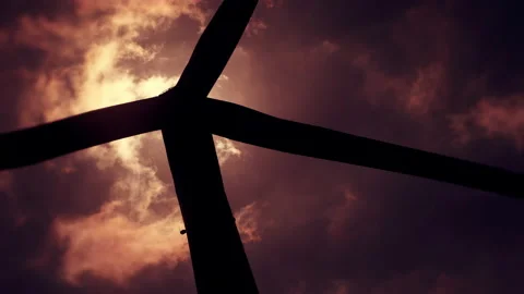 Silhouette of a rotating wind turbine with a dramatic sky - stylised. 4K tripod Stock Footage 157376804