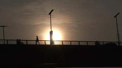 Silhouette of Runner on First Mactan Bridge at Golden Hour with Passing Traffic 動画素材 345970434