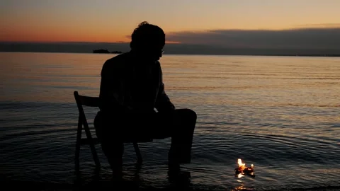 Silhouette of a sad man looking at a burning sheet of paper. Stock Footage 316106715