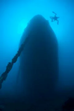 Silhouette of a scuba diver exploring the bow of a shipwreck, low angle view. Foto stock