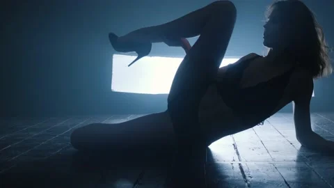 Silhouette of a sexy girl dancing an erotic sensual dance in blue smoke. Stock Footage