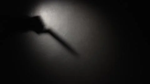 Silhouette shadow of a man with a knife on the wall, close-up. Stock Footage 321125243