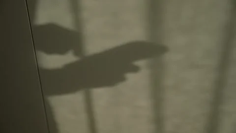 Silhouette shadow of man typing message on smartphone as sunlight shining on Stock Footage 345027809